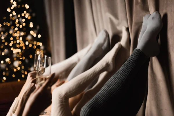 legs of four beautiful girls in stockings lie with champagne close-up