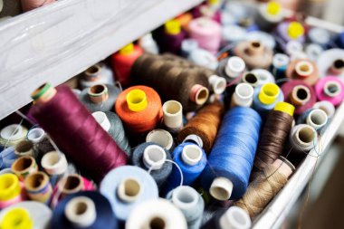 many spools of multi-colored threads lie in bulk