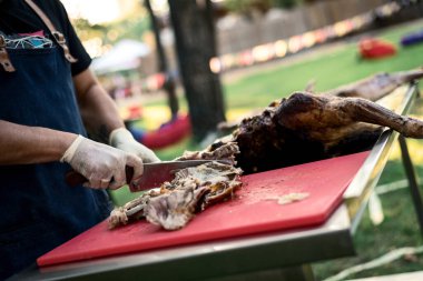 the hands of the cook cut the greased carcass of the rabbit