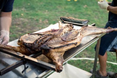 the hands of the cook cut the greased carcass of the rabbit