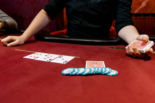 view of the hands of a man playing poker in a casino