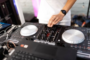 DJ, gece kulübünde canlı set ve pikabın konsolunda karışık müzik çalar. Disk Şakacı Eller kulüp partisinde ses karıştırıcı istasyonunda. Müzik çalmak ve parti yapmak için DJ karıştırıcı denetleyici paneli.