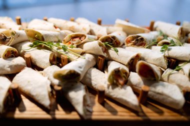 Taze dereotuyla dekore edilmiş beyaz bir tabakta etli bir rulo krep. Yan plan yakın plan. Maslenitsa için geleneksel krepler.