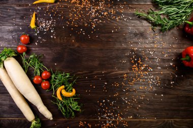 Mutfak mutfağı: kiraz domatesleri, soğanlar, baharatlar ve otlar. Siyah bir arkaplanda.