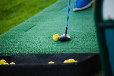 Golf sopası ve top yeşil çimlerin üzerinde, yakın plan.