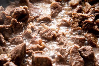 Yakın plan güzel büyük et parçaları ve tavada soğan.