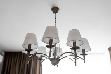 Birkaç lambadan oluşan yuvarlak bir avize. Açık tavan, tam çerçeve, yan görüş. yatay çerçeve