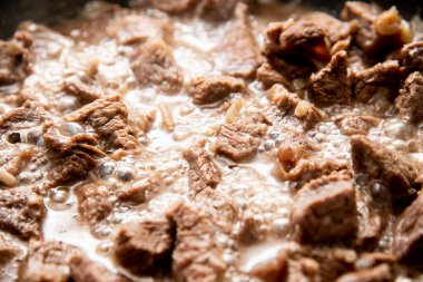 Yakın plan güzel büyük et parçaları ve tavada soğan.