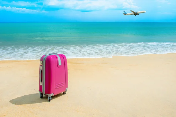 太陽が降り注ぐビーチでスーツケース — ストック写真