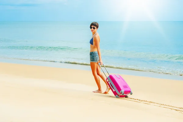 Femme avec une valise sur la plage — Photo