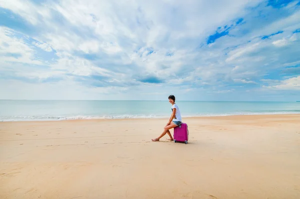 Frau mit Koffer am Strand — Stockfoto