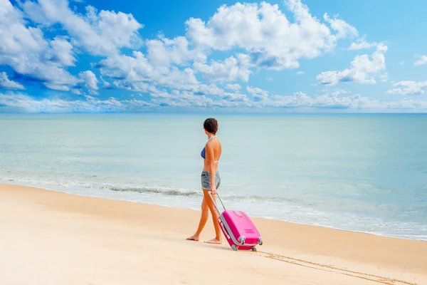 Mulher com uma mala na praia — Fotografia de Stock