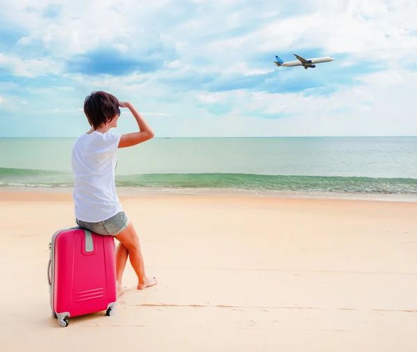 Woman with a suitcase on the beach — Stock Photo, Image