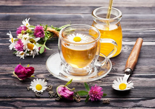 Herbal tea with honey and flowers. Chamomile tea, tea with rose petals and flowers clover.