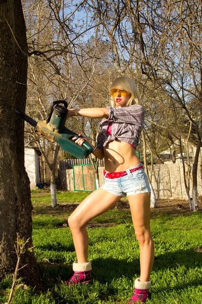 Sexig tjej håller en motorsåg — Stockfoto