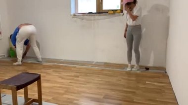 Çift tadilat yapıyor. Karı koca evde tamirat yapıyor. Duvar kağıdını yapıştırın. Hızlı hareket, Zaman Hızı.