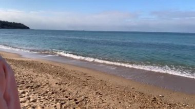 Güzel sarışın bir kadın, kalın bir ceket ve botlar içinde, sonbaharda dinlenmek için acele etti. Denize bakar, sevinir, zıplar, daireler çizer ve gülümser..