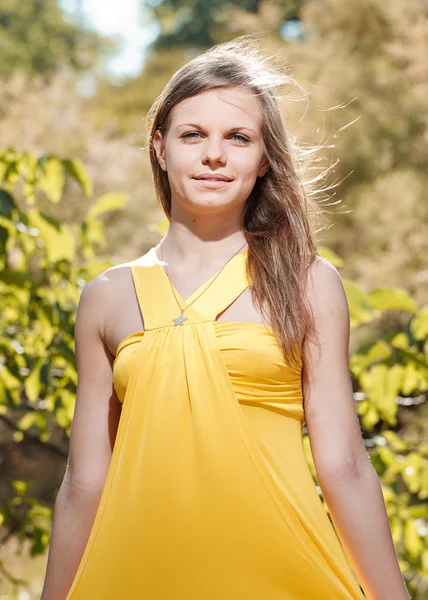 Όμορφο κορίτσι σε ένα κίτρινο φόρεμα σχετικά με τη φύση — Φωτογραφία Αρχείου