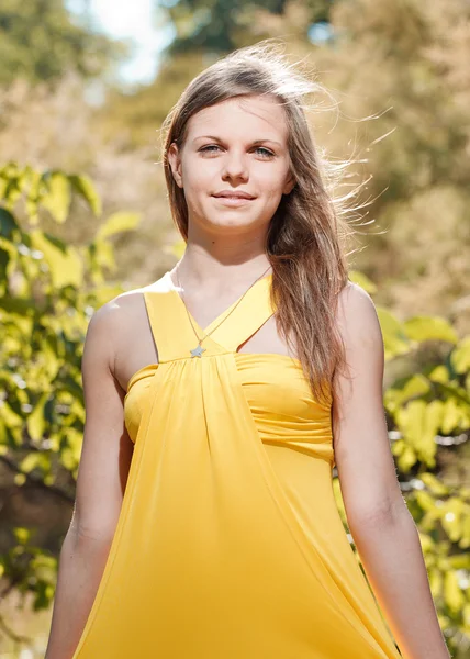 Hermosa chica en un vestido amarillo en la naturaleza —  Fotos de Stock