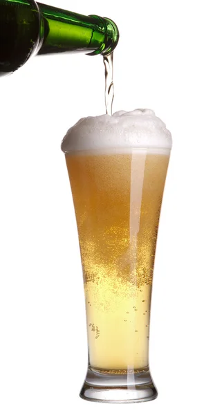 Пиво разливается из зеленой бутылки в стекло, изолированное на белом — стоковое фото