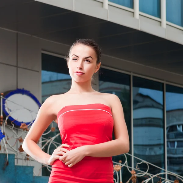 Beauty woman in red dress in the city at summer time — Stock Photo, Image