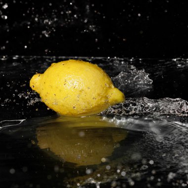 limon siyah arka plan üzerinde tatlı su damlaları