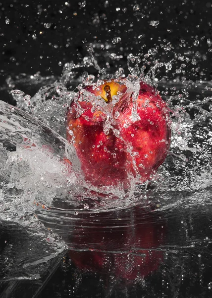 Färska ett äpple i strömmande stänk vatten på svart bakgrund — Stockfoto