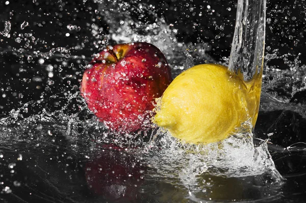 Frischwassertropfen auf Zitrone und Apfel auf schwarzem Hintergrund — Stockfoto