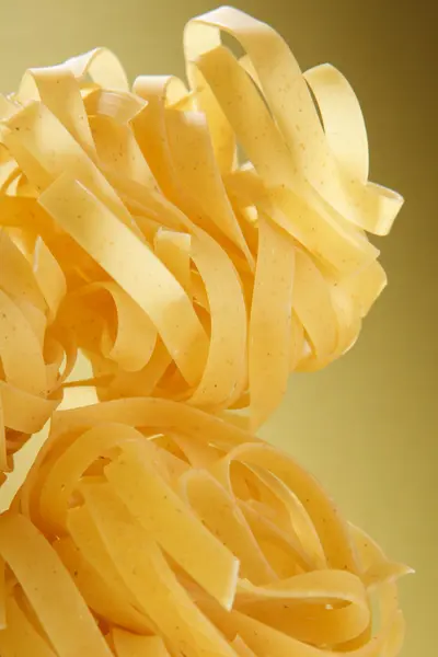 Italian pasta close-up on yellow gradient surface. — Stock Photo, Image