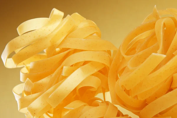 Italian pasta close-up on yellow gradient surface. — Stock Photo, Image