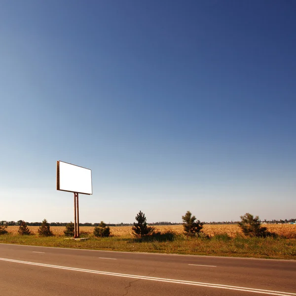 Yol boş bir billboard ile bir köyde — Stok fotoğraf