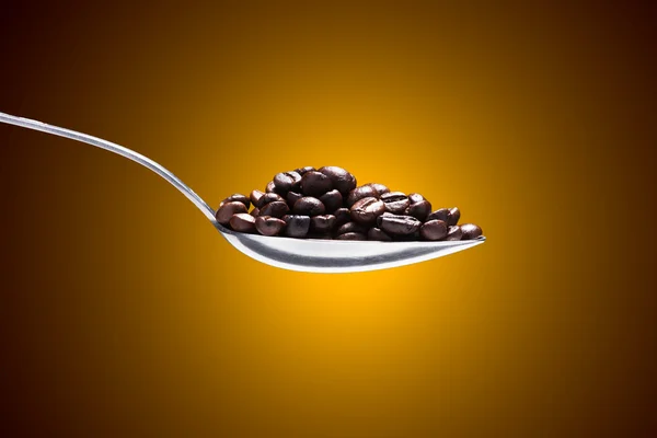 Grains de café sur une cuillère — Photo