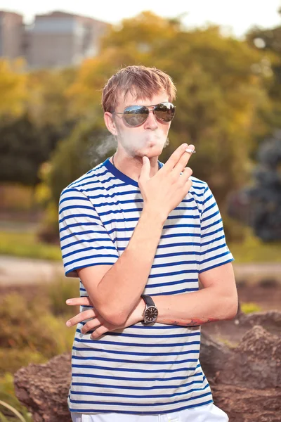 Homem fumando um cigarro lá fora — Fotografia de Stock