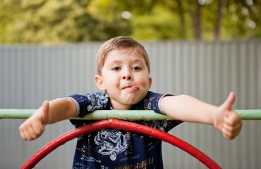 mutlu sevimli genç çocuk oyun alanı üzerinde gülümseyen