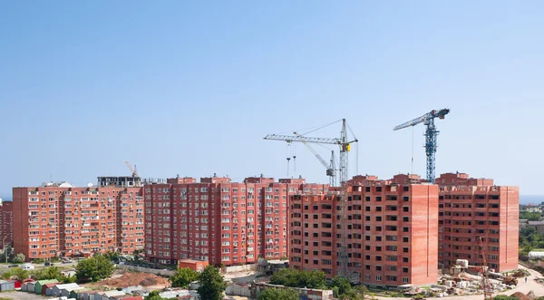 The elevating crane against the dark blue sky, building a monoli — Stock Photo, Image
