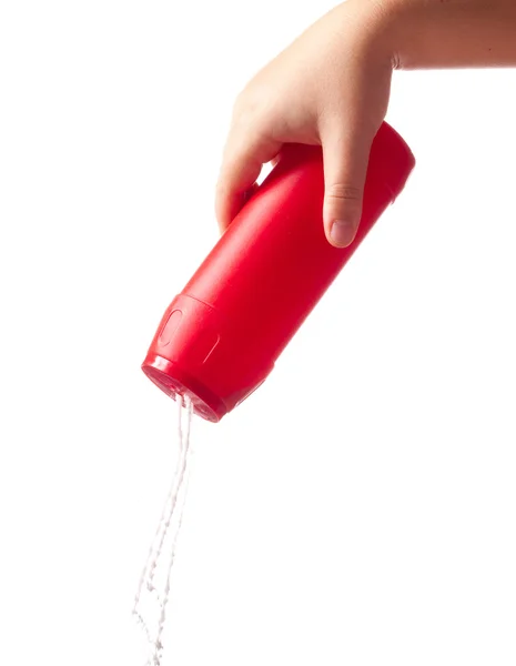 Butelka czerwony z czyszczenia proszek w ręku na białym tle na biały — Zdjęcie stockowe