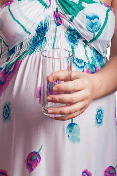 เด็กผู้หญิงเทของเหลวลงในแก้ว แยกบนสีขาว — ภาพถ่ายสต็อก