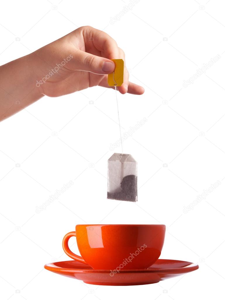 Woman hand with teabag and red cup isolated on white background