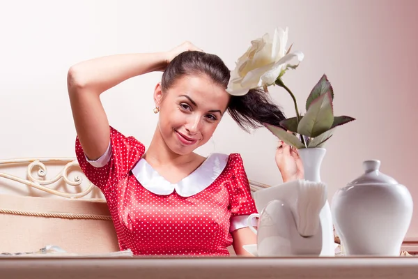 Bella giovane donna in abito rosso siede a tavola nel ristorante — Foto Stock