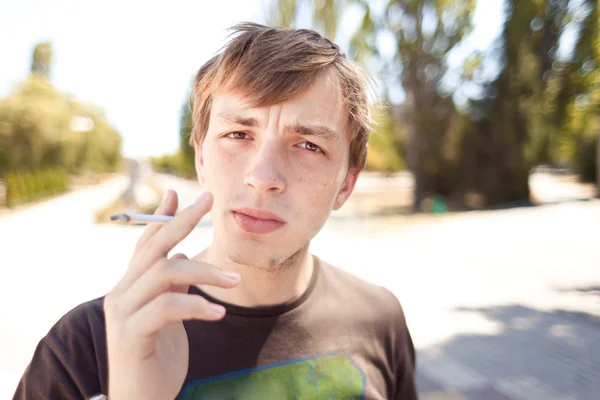 Closeup portrait of handsome smoking young man — Stock Photo, Image