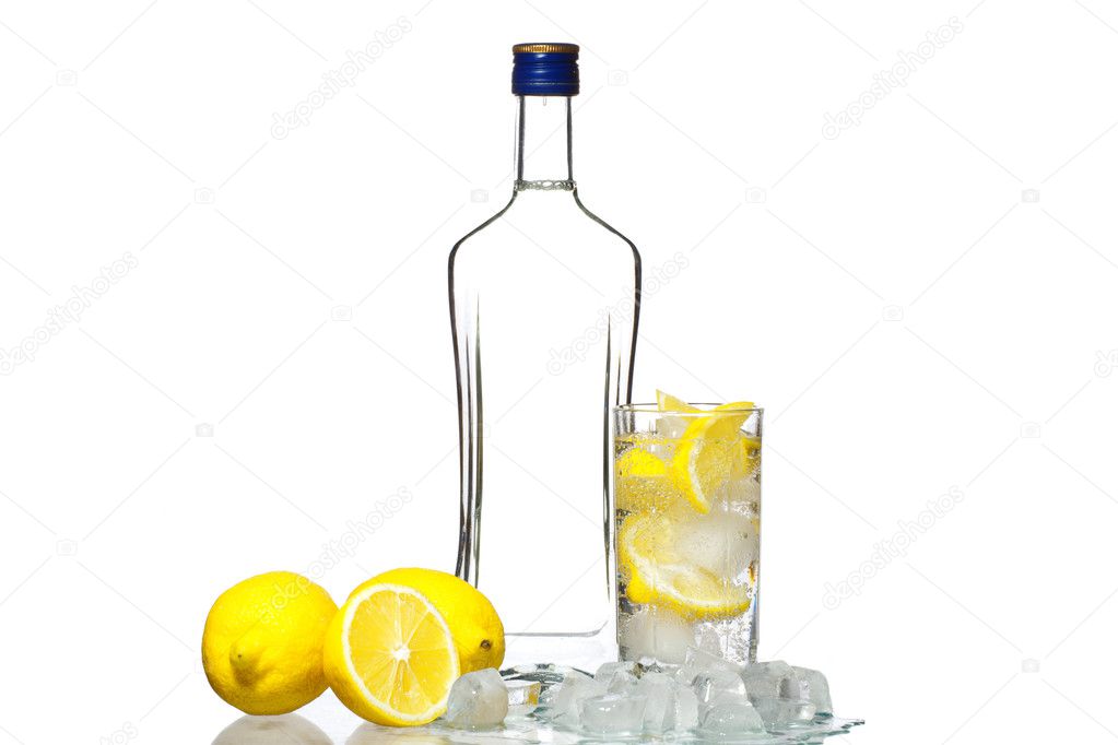 Bottle of vodka and wine glass with lemon and ice isolated on wh