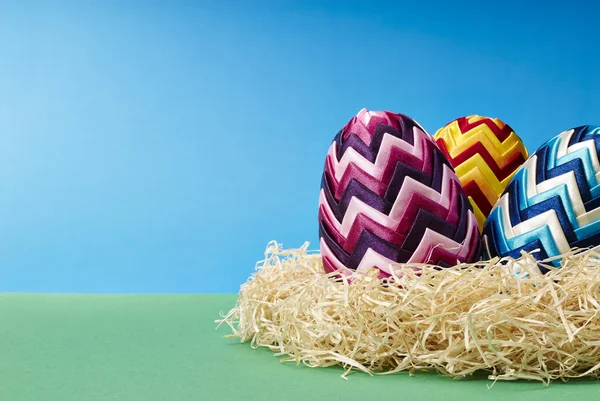 Velikonoční vajíčka v seně — Stock fotografie