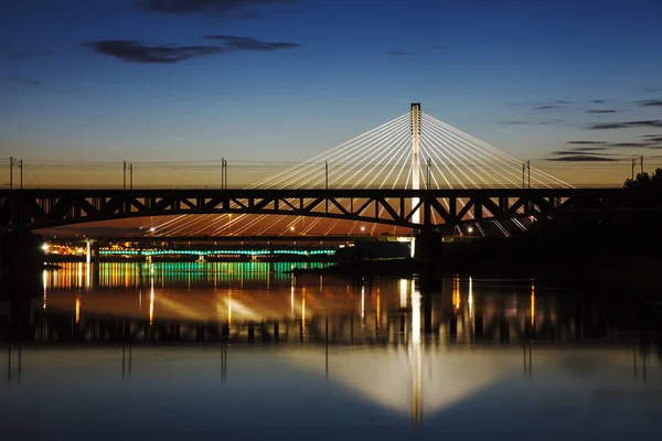 Gemarkeerde brug bij nacht en gereflecteerd in het water — Stockfoto