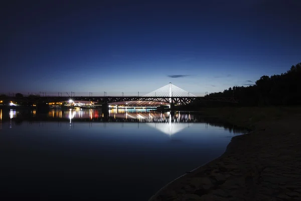 Pont en surbrillance la nuit et reflété dans l'eau — Photo