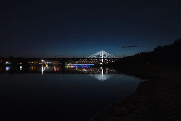 Pont en surbrillance la nuit et reflété dans l'eau — Photo