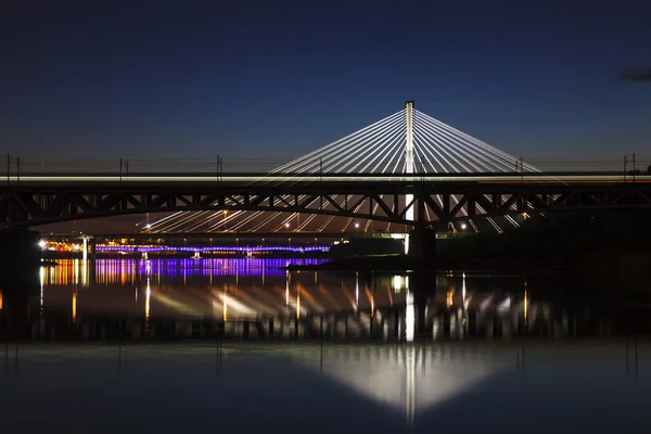 Beleuchtete Brücke in der Nacht und spiegelt sich im Wasser — Stockfoto
