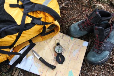 Hiking shoes on map with compass clipart