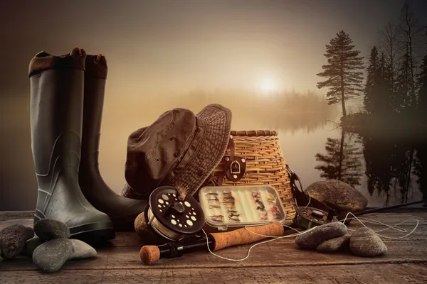 Fly fishing equipment on deck with view of a misty lake — Stock Photo, Image