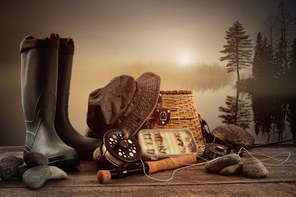 Fly fishing equipment on deck with view of a misty lake