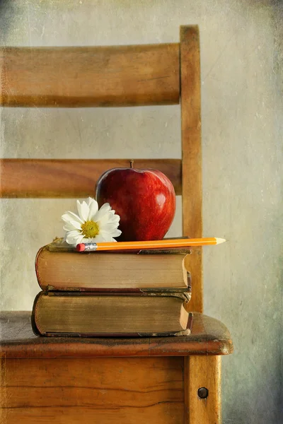 Jabłko i starych książek na krzesło szkolne — Zdjęcie stockowe